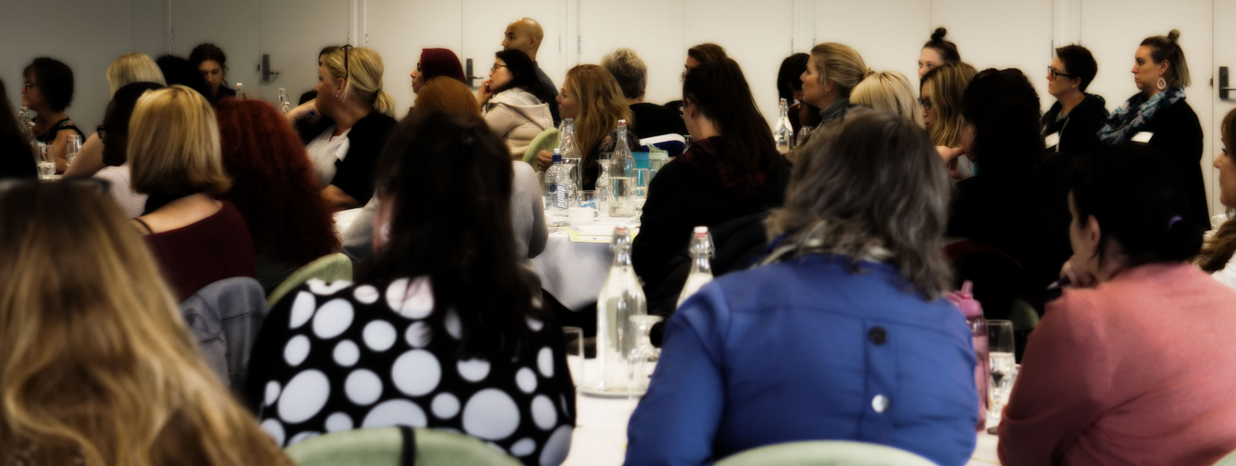 people listening to a speaker at a forum